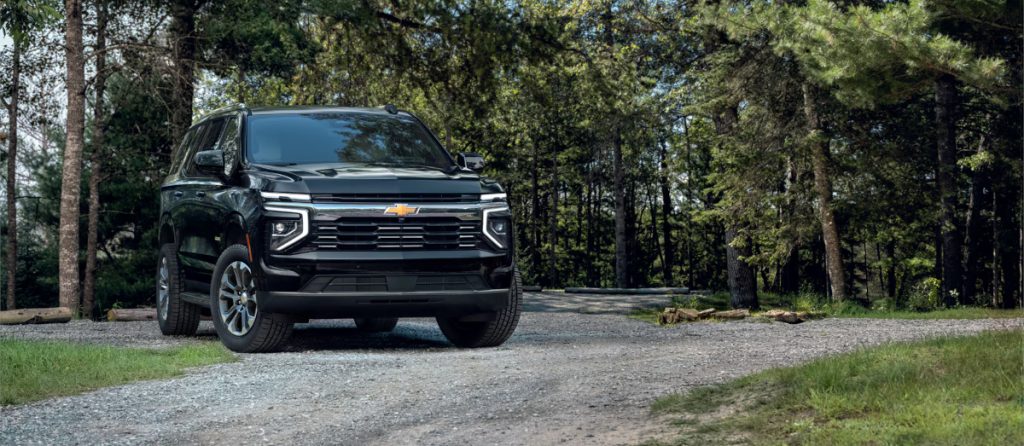 Image of a black 2025 Chevrolet Tahoe on a gravel path in a forest