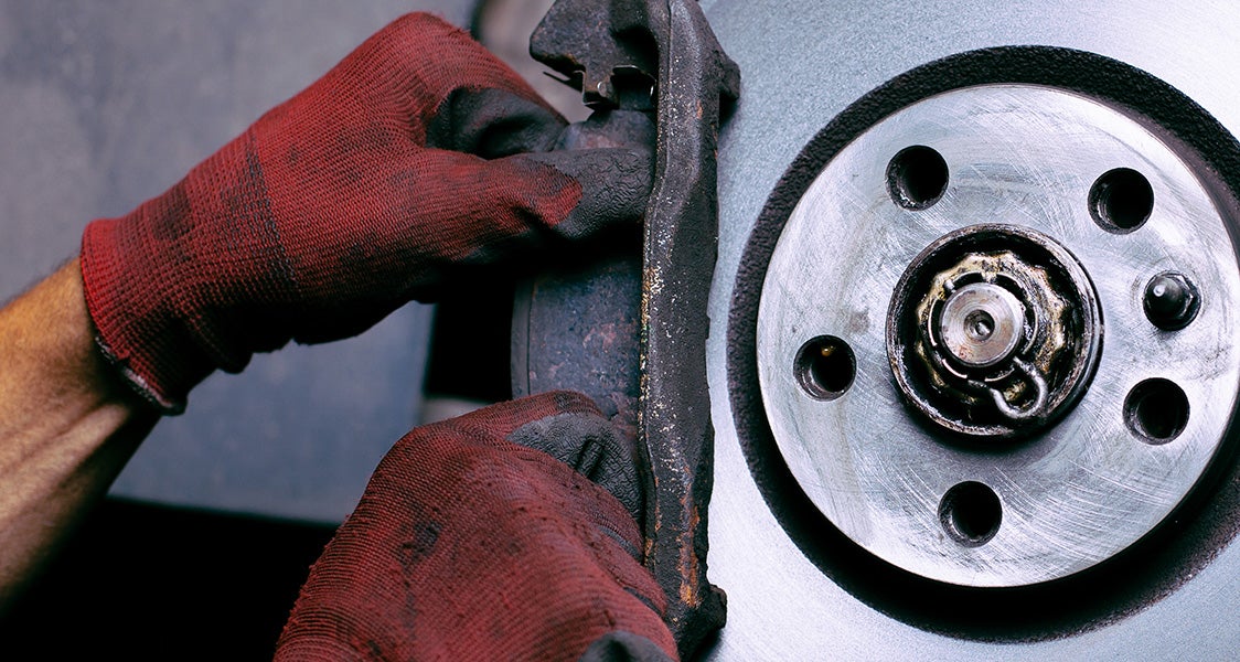 Certified technician inspecting brake pads and rotors on a Chevy Equinox